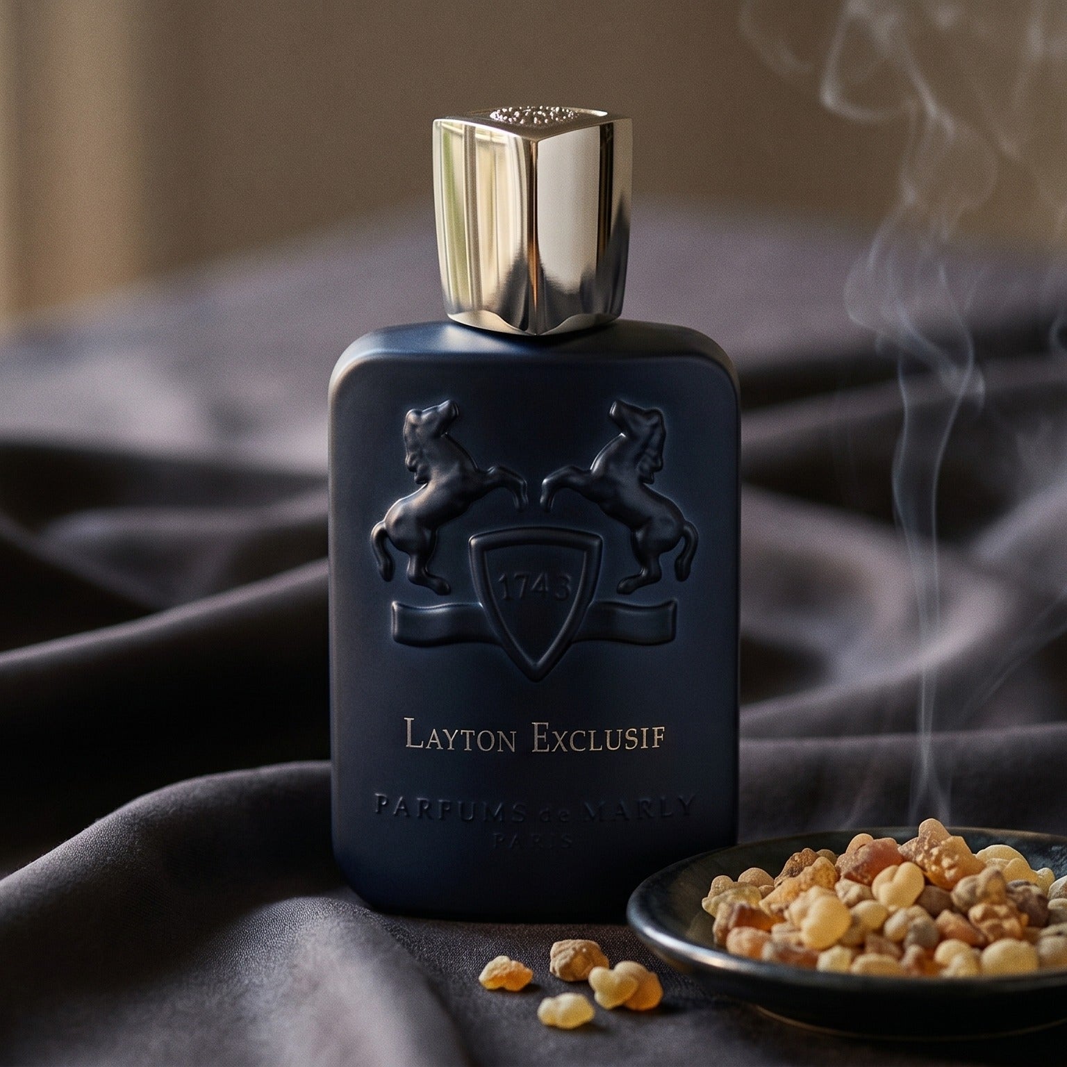Parfums de Marly Layton Exclusif EDP on charcoal silk with frankincense resin granules in a small saucer