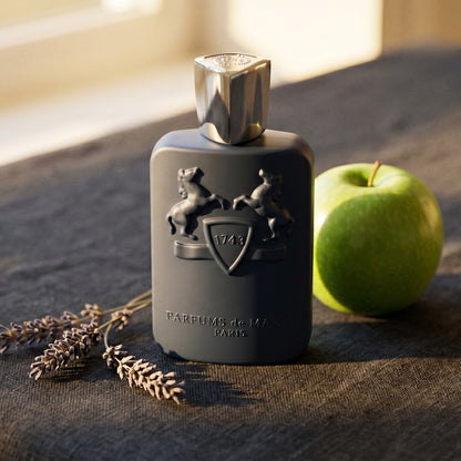 Parfums de Marly Layton on charcoal linen with a green apple and dried lavender