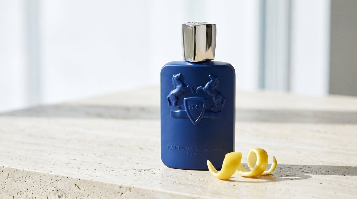 Parfums de Marly Percival EDP on pale travertine with a lemon peel curled beside the bottle