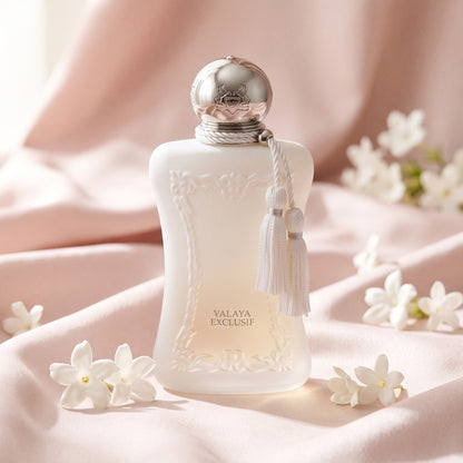 Parfums de Marly Valaya Exclusif EDP on pale pink silk with a few white flowers laid softly