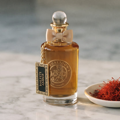 Penhaligon's Halfeti Amber EDP - Dubai Exclusive on pale grey marble with a small white ceramic dish of crimson saffron threads