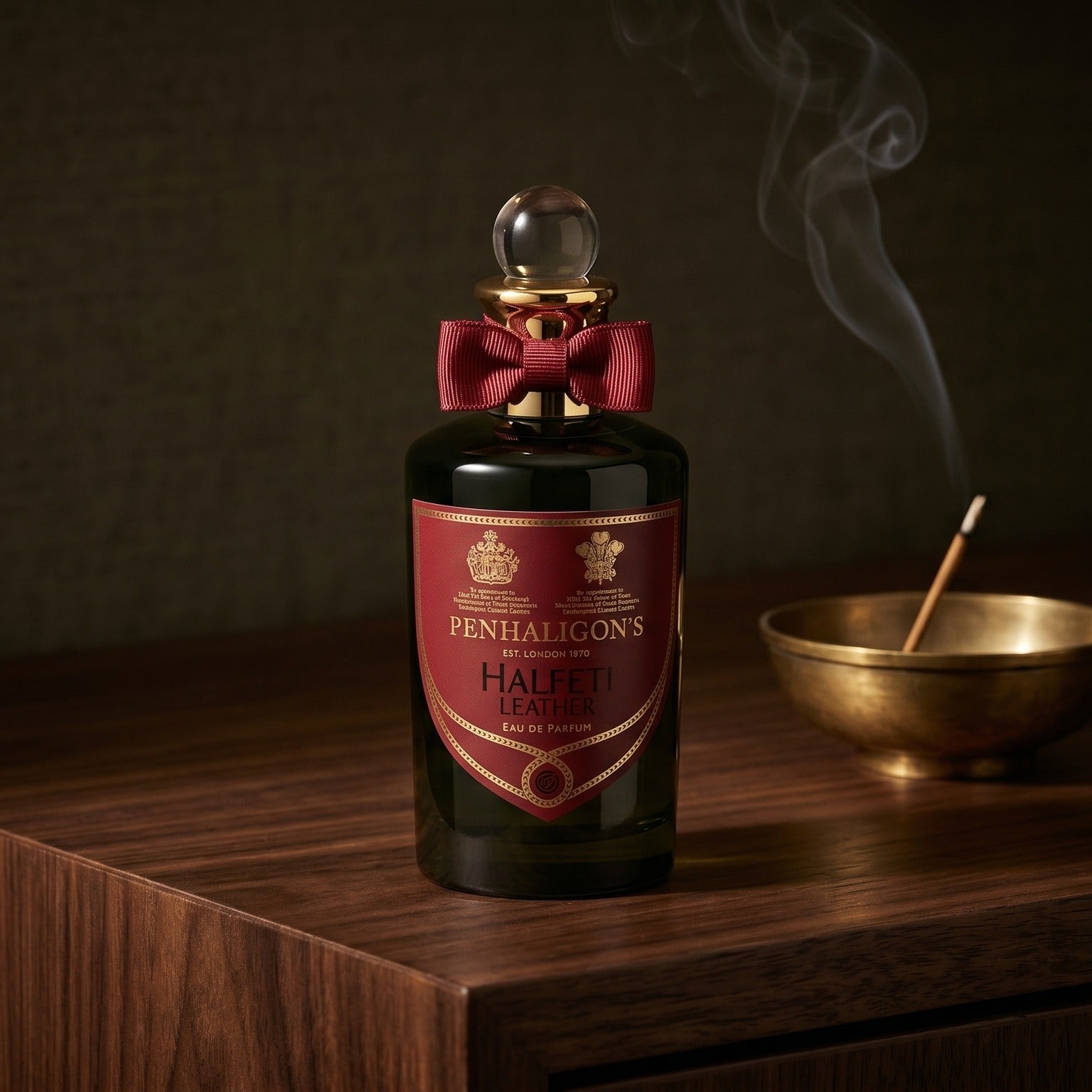Penhaligon's Halfeti Leather EDP on dark walnut console with a small brass incense bowl, smoke curling upward