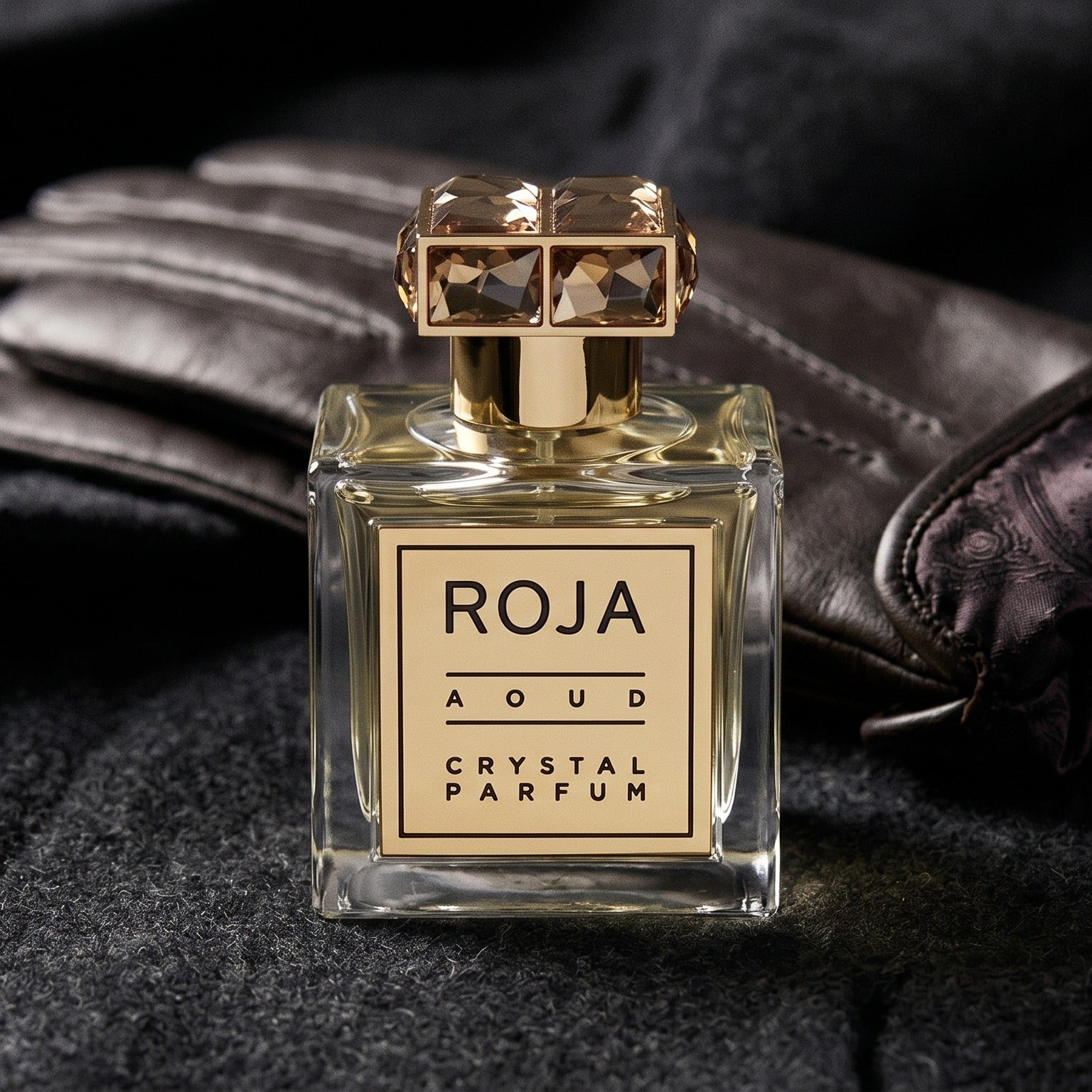 Roja Aoud Crystal Parfum on smoke-grey wool with a folded pair of driving gloves to the side