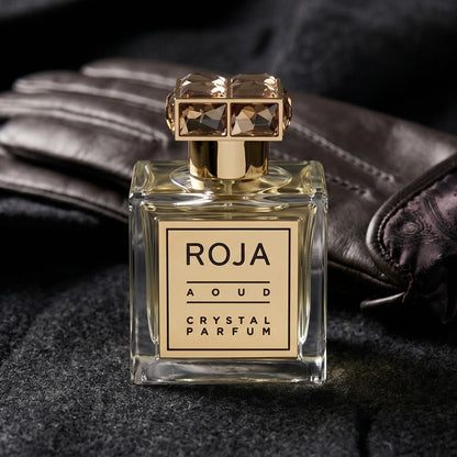 Roja Aoud Crystal Parfum on smoke-grey wool with a folded pair of driving gloves to the side