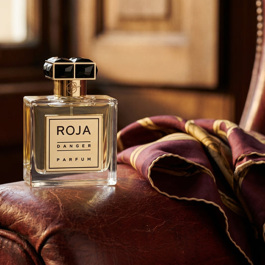 Roja Danger Pour Homme Parfum on vintage oxblood leather chair arm with a folded silk scarf