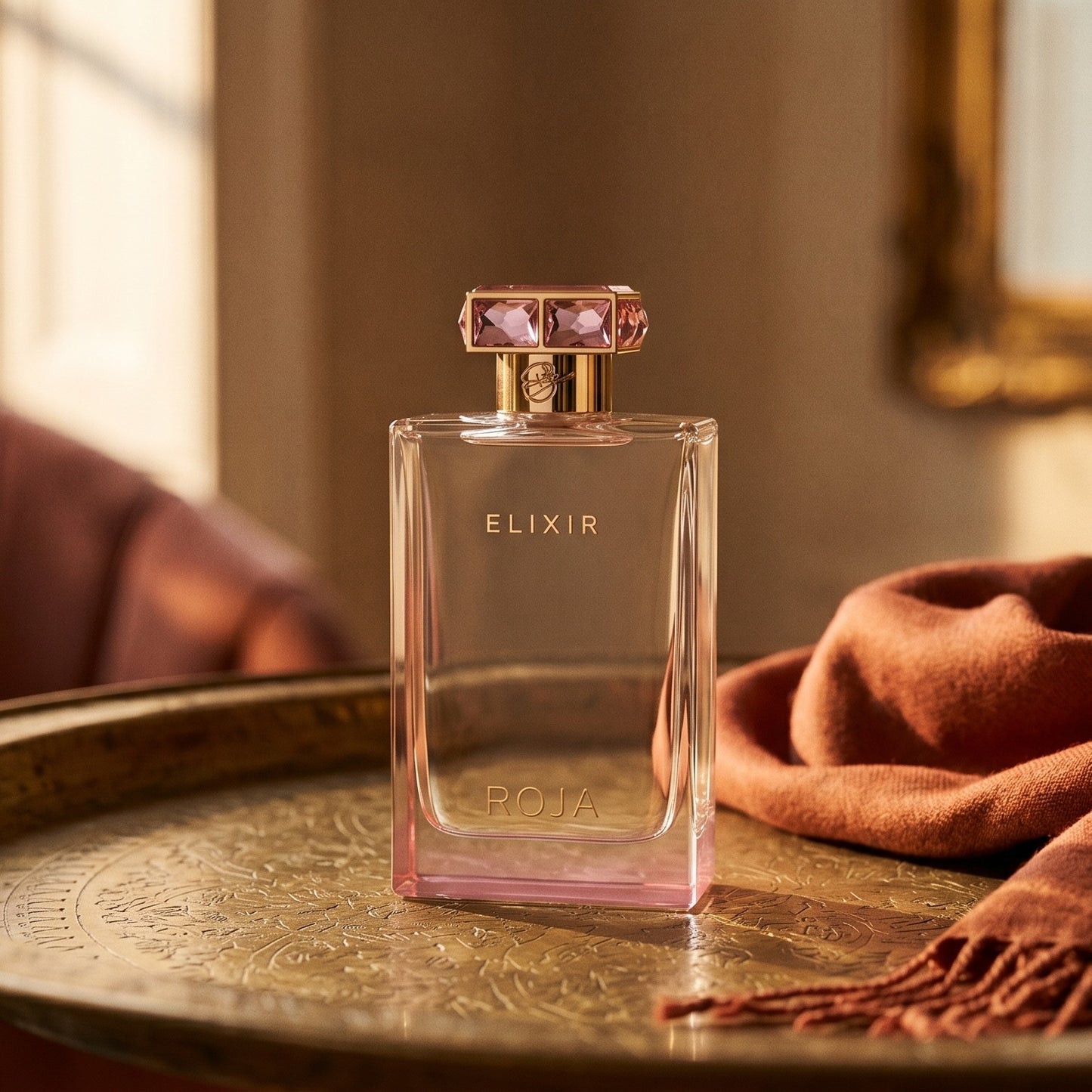 Roja Elixir Pour Femme EDP on aged brass tray with a folded pashmina in rust tone