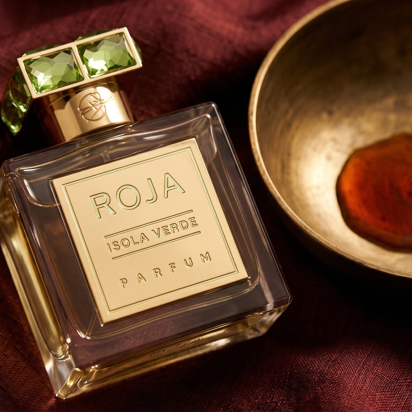 Roja Isola Verde Parfum on cinnamon-tone silk with a shallow saucer of warm benzoin resin