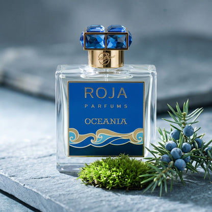 Roja Oceania EDP on grey stone slab with a tuft of green moss beside a sprig of juniper