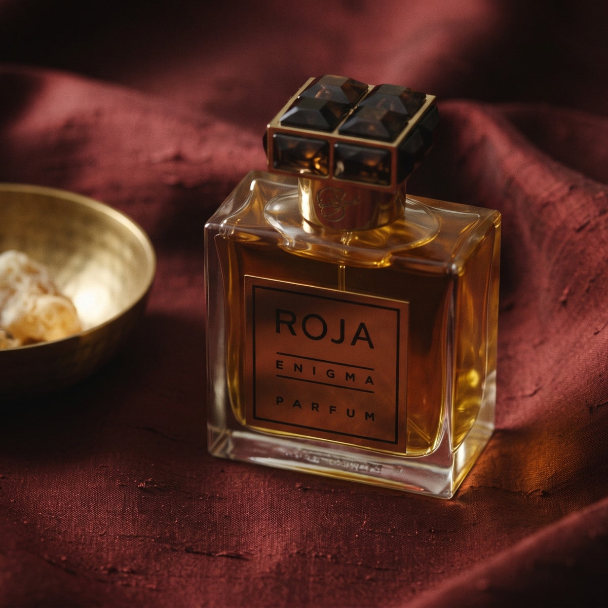 Roja Enigma Pour Homme Parfum on raw silk of oxblood color with a brass bowl with ambergris tincture