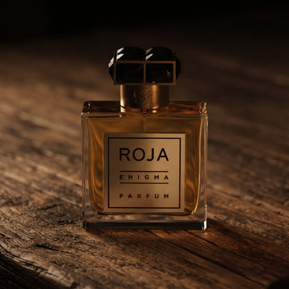 Roja Enigma Pour Homme Parfum on aged teak with a candle burning gently to frame-right