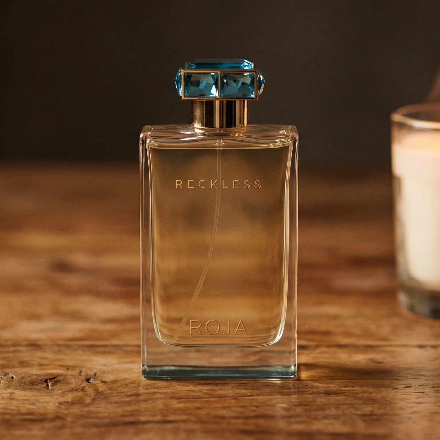 Roja Reckless Pour Femme EDP on walnut side table with a pair of lit votives beside the bottle