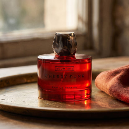 Room 1015 Cherry Punk EDP on patinated bronze tray with a folded shawl in deep saffron