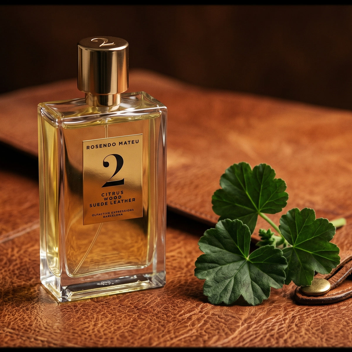 Rosendo Mateu No. 2 EDP on aged cognac-leather surface with a small sprig of geranium leaf