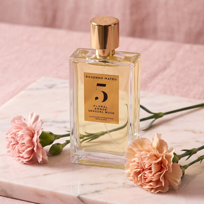 Rosendo Mateu No. 5 EDP on pale pink marble with two carnation stems laid softly