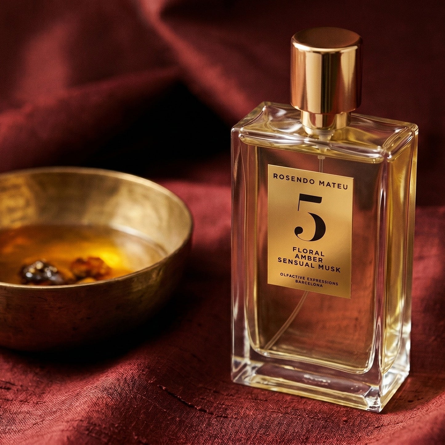Rosendo Mateu No. 5 EDP on burnt-orange raw silk with a brass vial of frankincense oil