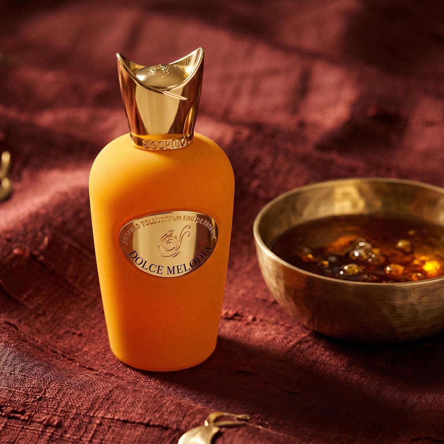 Sospiro Dolce Melodia EDP on burnt-orange raw silk with a brass vial of frankincense oil