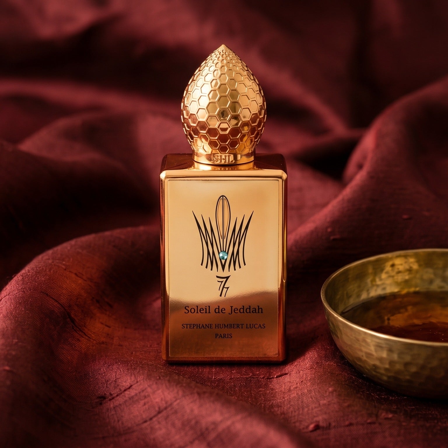 Stephane Humbert Lucas 777 Soleil de Jeddah Mango Kiss on russet silk with a matte brass bowl holding tonka and amber pieces