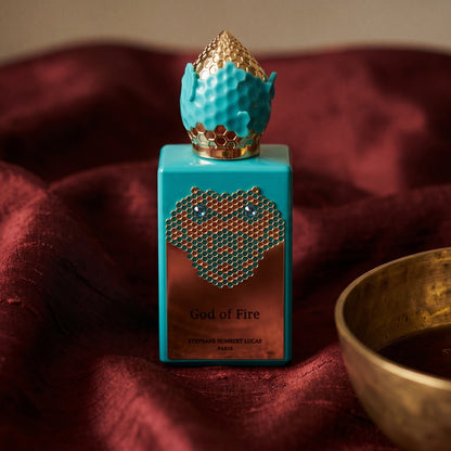 Stephane Humbert Lucas God of Fire on burnt-orange raw silk with a brass vial of frankincense oil