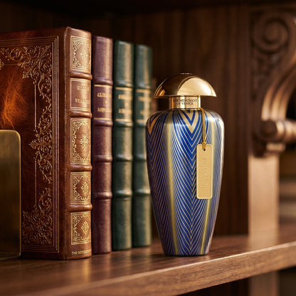 The Merchant of Venice Vinegia 21 EDP on dark walnut library shelf with a leather-bound book trimmed in gold foil