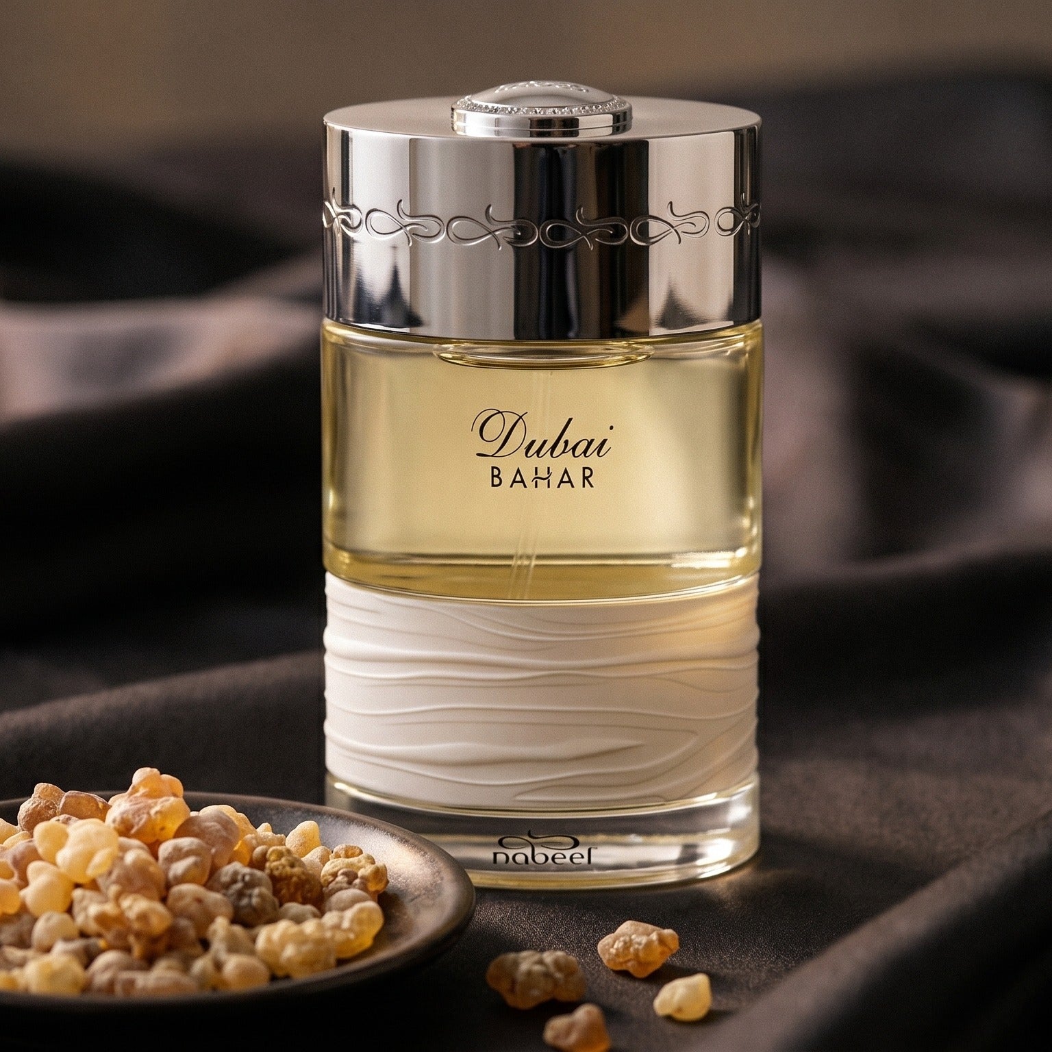 The Spirit of Dubai Bahar on charcoal raw silk with amber resin pieces near the bottle base