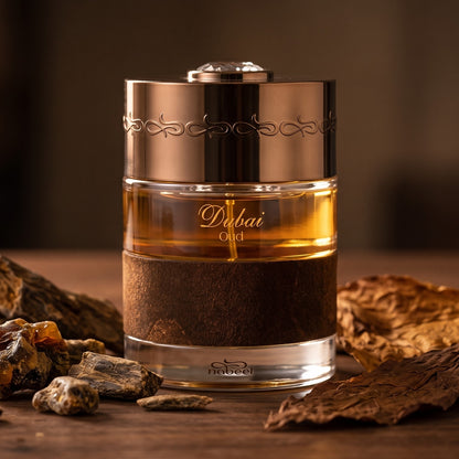 The Spirit of Dubai Oud EDP on dark walnut wood with agarwood chips and tobacco leaves