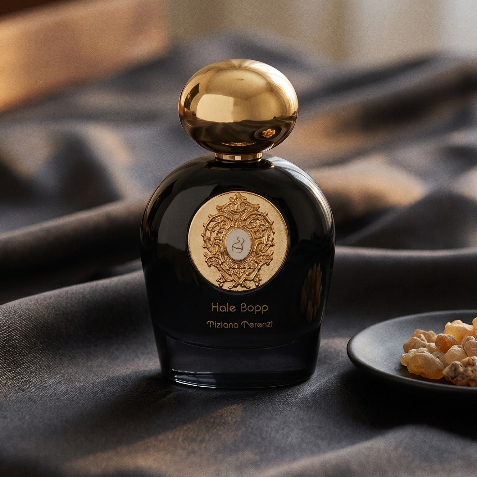 Tiziana Terenzi Hale Bopp Ext on charcoal raw silk with amber resin pieces near the bottle base