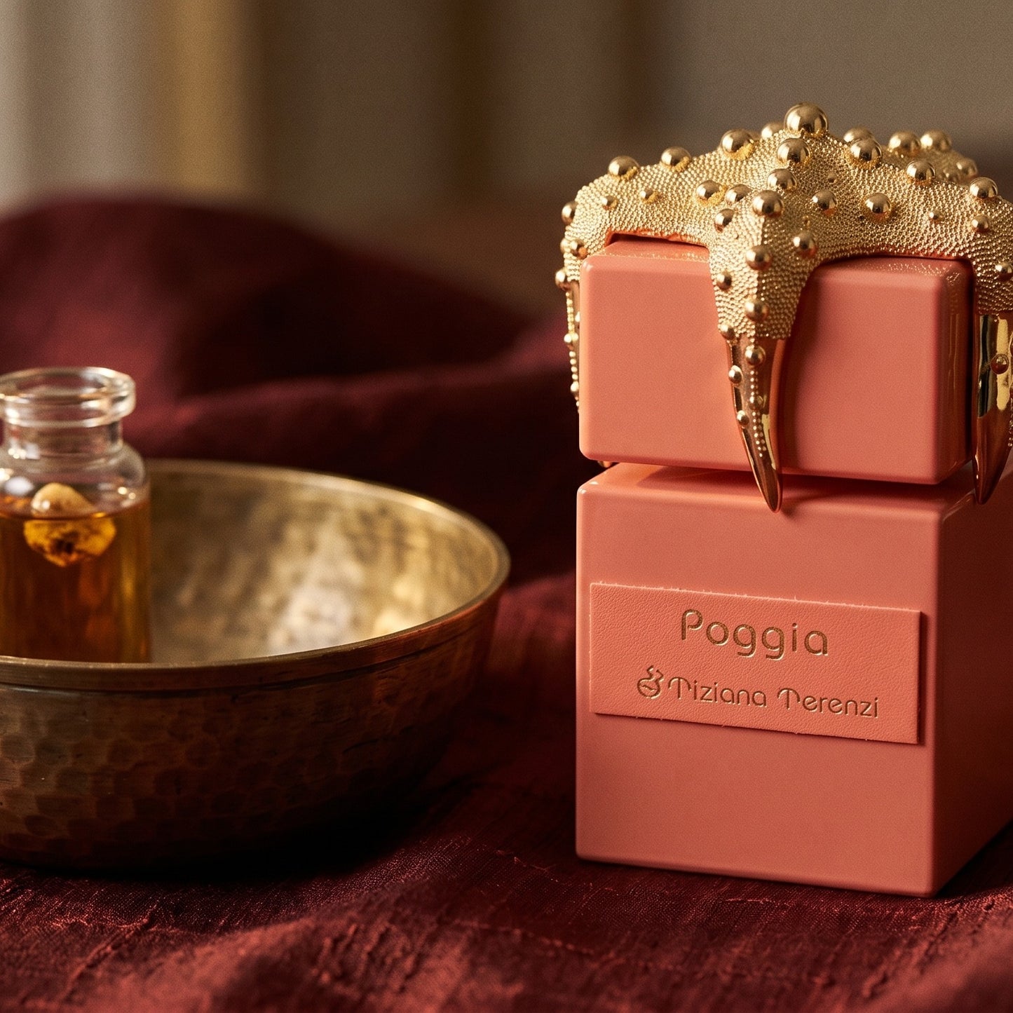 Tiziana Terenzi Poggia on amber-toned satin with a gold-rim ceramic dish of labdanum