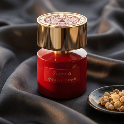 Tiziana Terenzi Porpora EDP on burnt-orange silk with smoldering agarwood on a stone dish