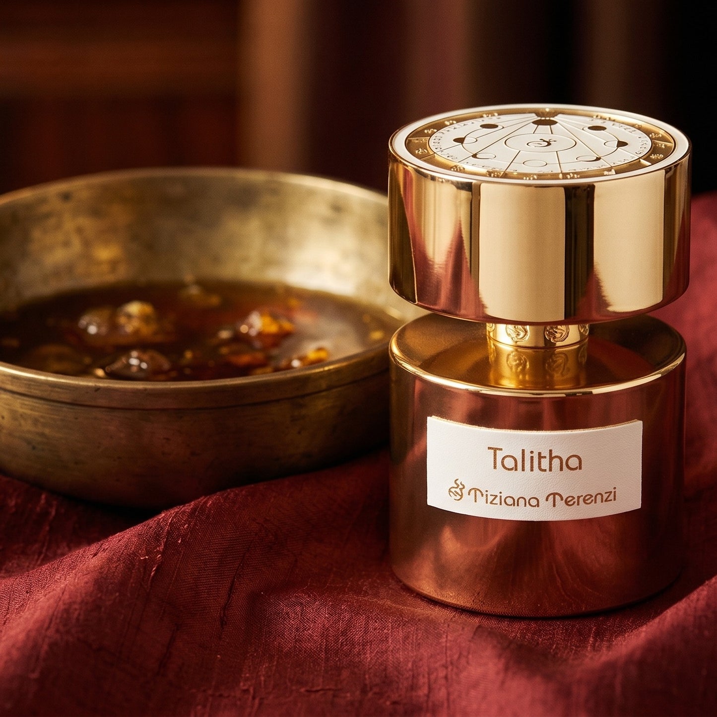 Tiziana Terenzi Talitha EDP on burnt-orange raw silk with a brass vial of frankincense oil