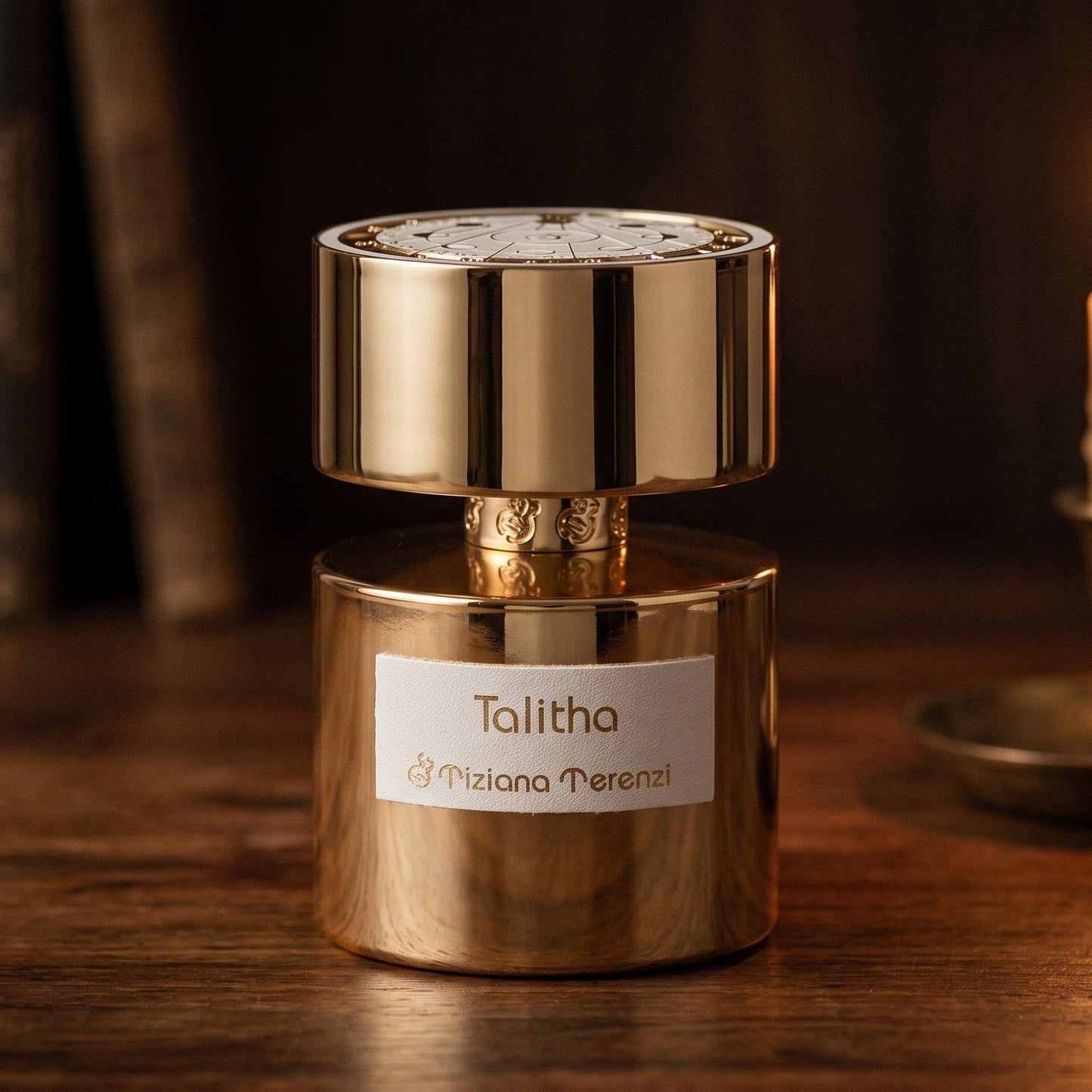 Tiziana Terenzi Talitha EDP on dark cherrywood with a tall beeswax taper casting warm light
