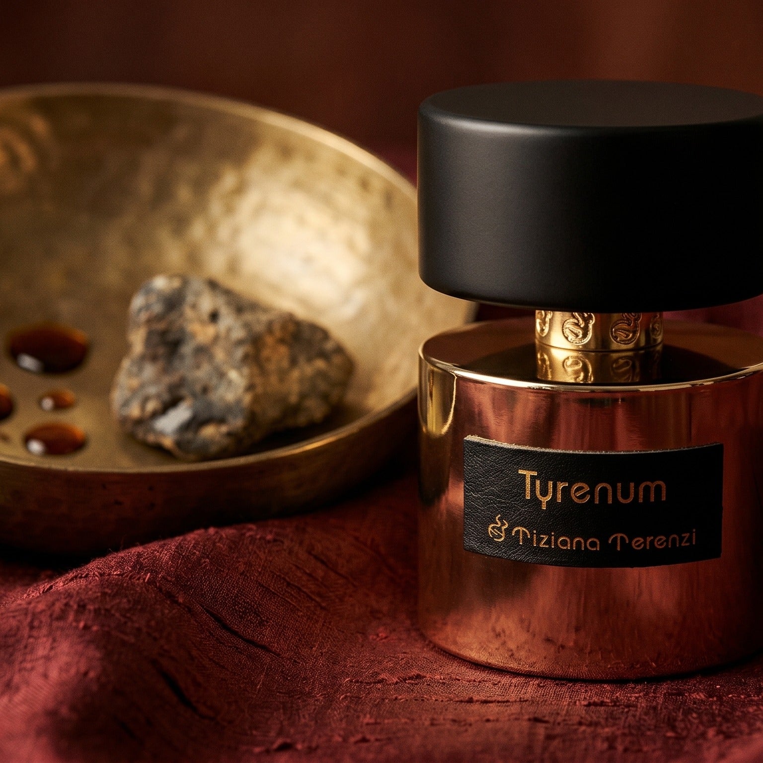 Tiziana Terenzi Tyrenum EDP on deep caramel velvet with a small copper jar of resin balm