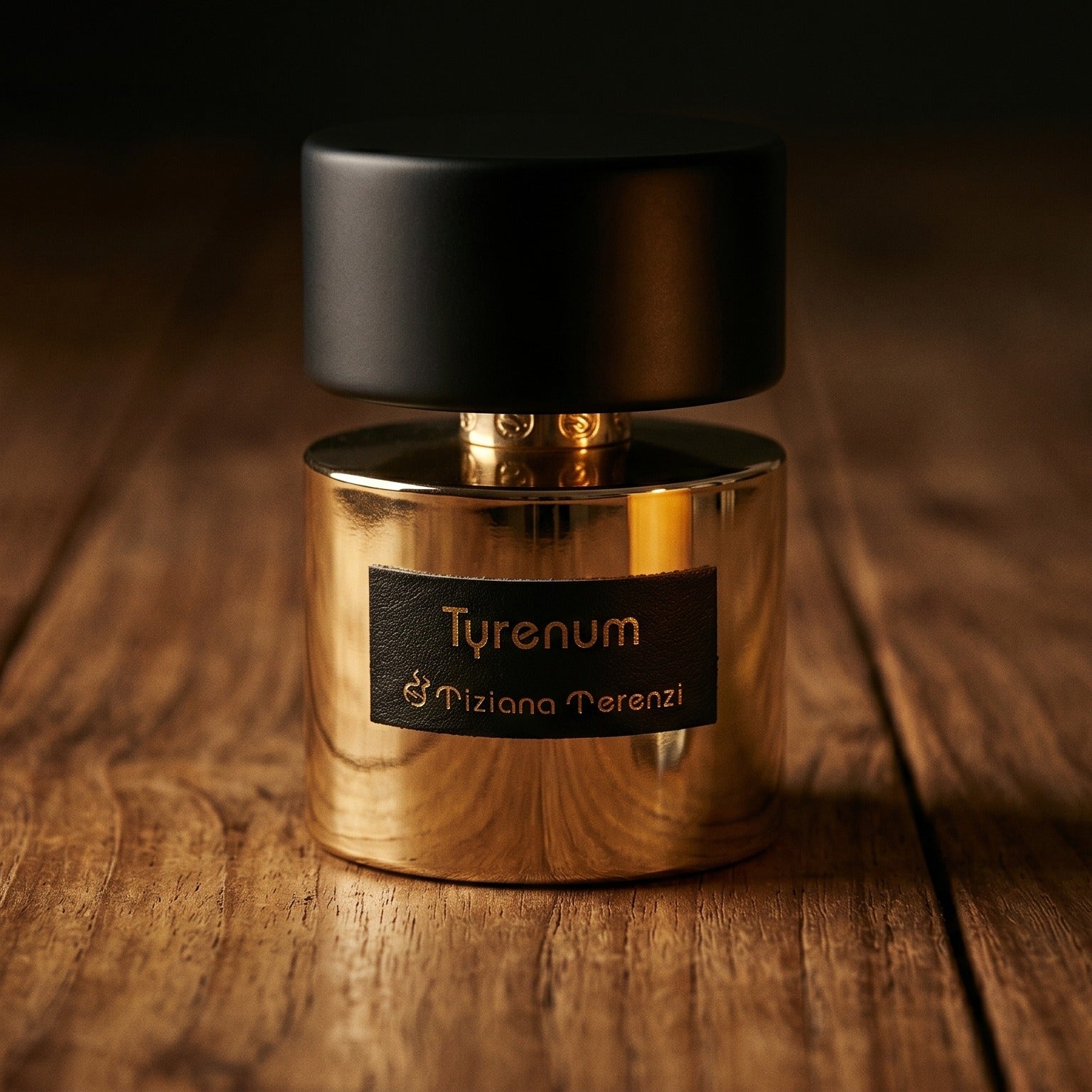 Tiziana Terenzi Tyrenum EDP on reclaimed oak surface with a glass hurricane lamp softly glowing