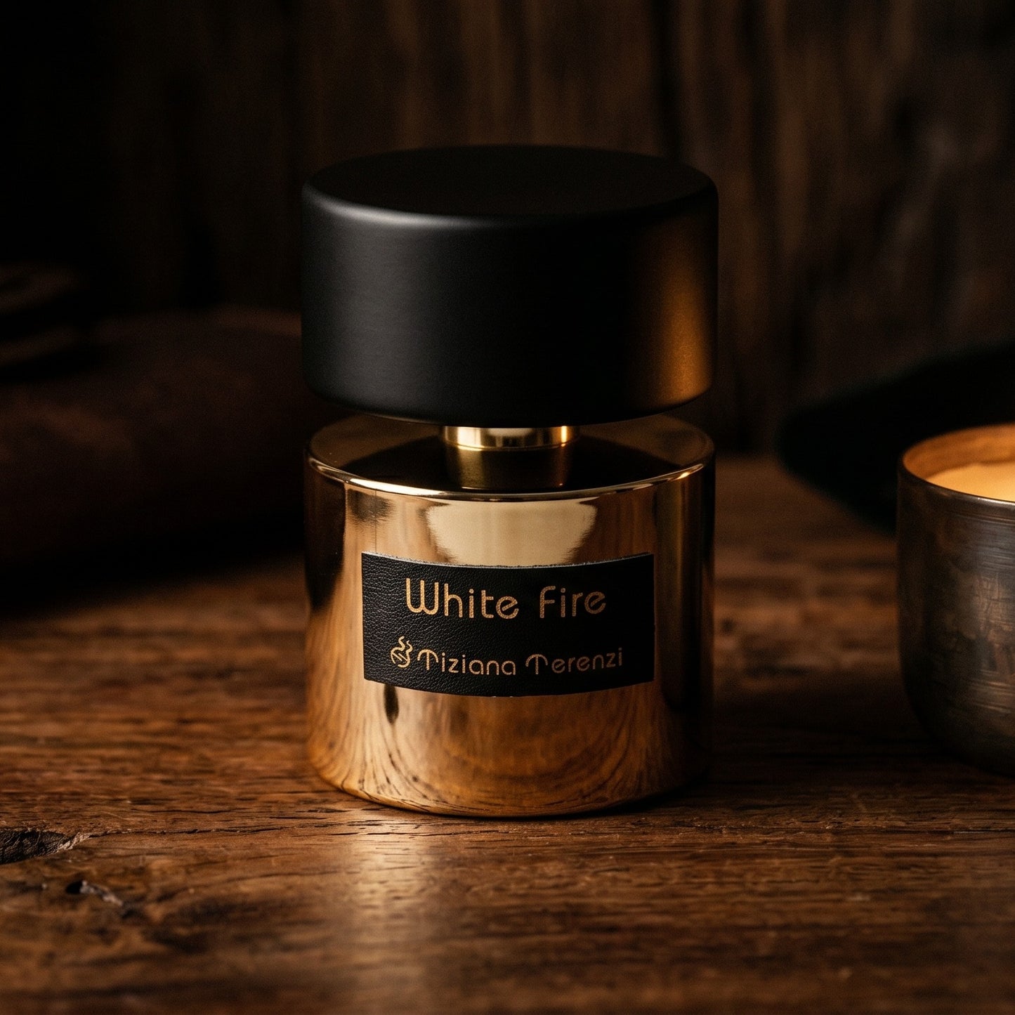 Tiziana Terenzi White Fire on dark cherrywood with a tall beeswax taper casting warm light