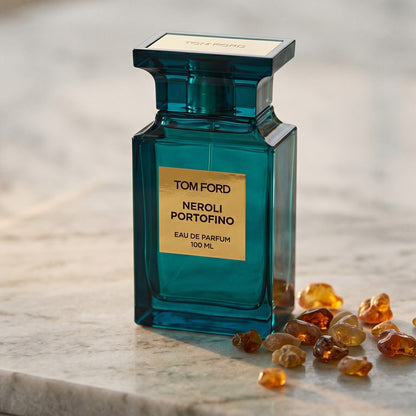 Tom Ford Neroli Portofino on warm ivory travertine with labdanum chunks clustered by the base