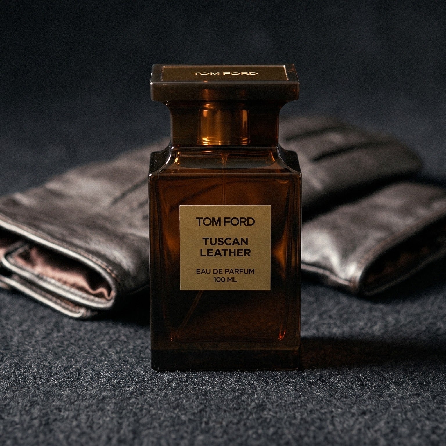 Tom Ford Tuscan Leather on charcoal felt with a silk-lined glove just behind the bottle