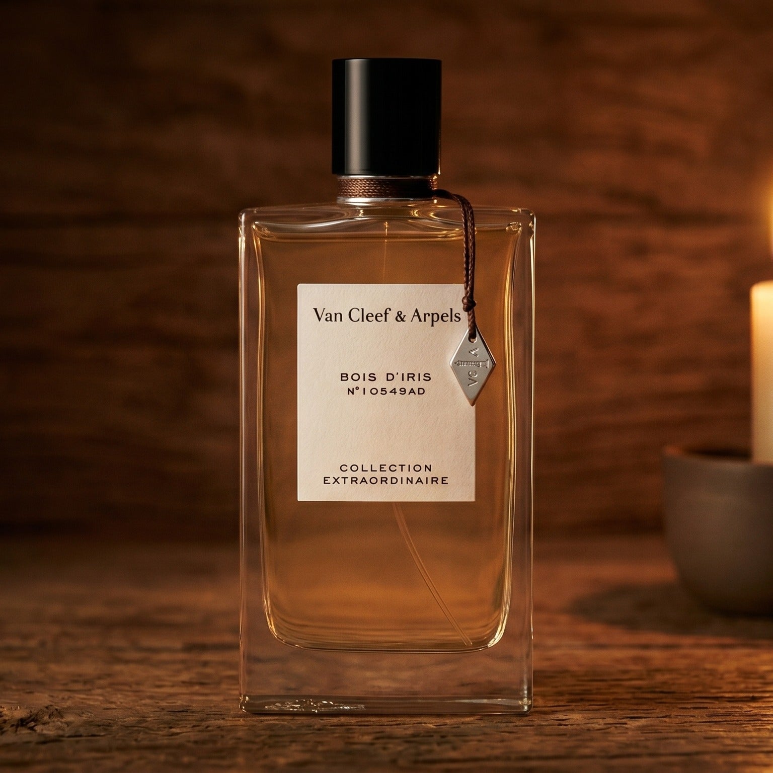 Van Cleef Bois Diris EDP on reclaimed oak surface with a glass hurricane lamp softly glowing