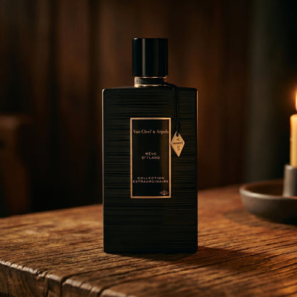 Van Cleef Reve de Ylang on walnut side table with a pair of lit votives beside the bottle