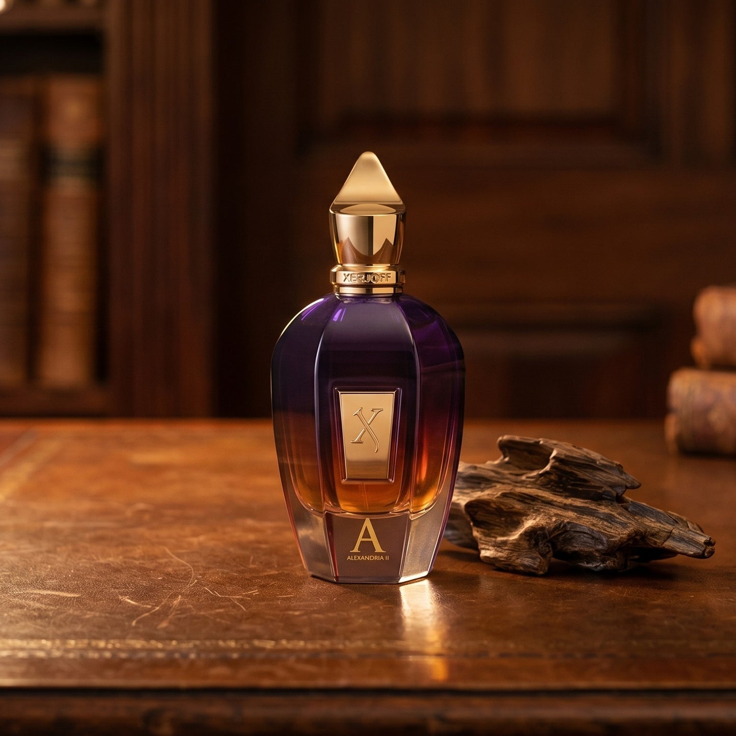 Xerjoff Alexander II on aged leather-topped desk with a single agarwood chip beside the bottle