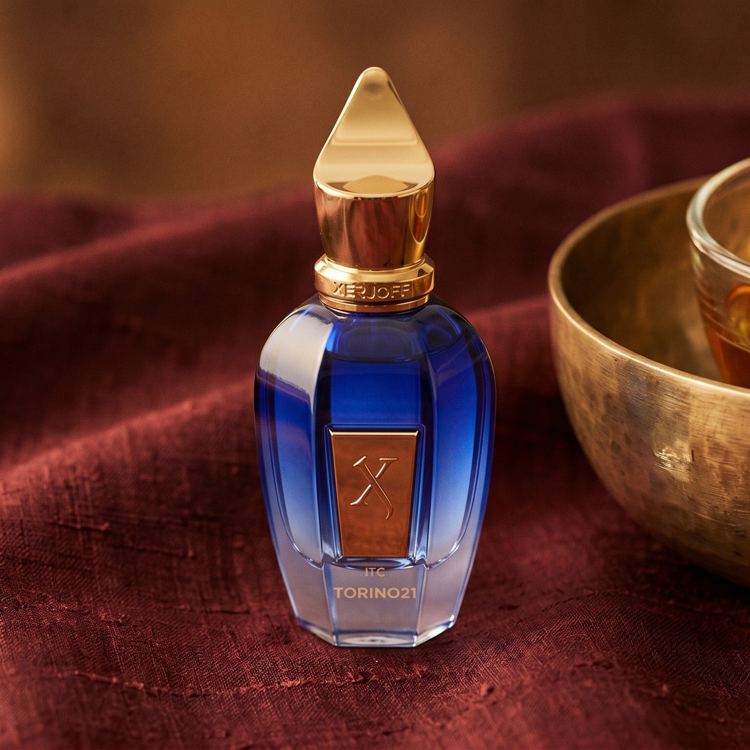 Xerjoff Torino 21 on raw silk of oxblood color with a brass bowl of ambergris tincture