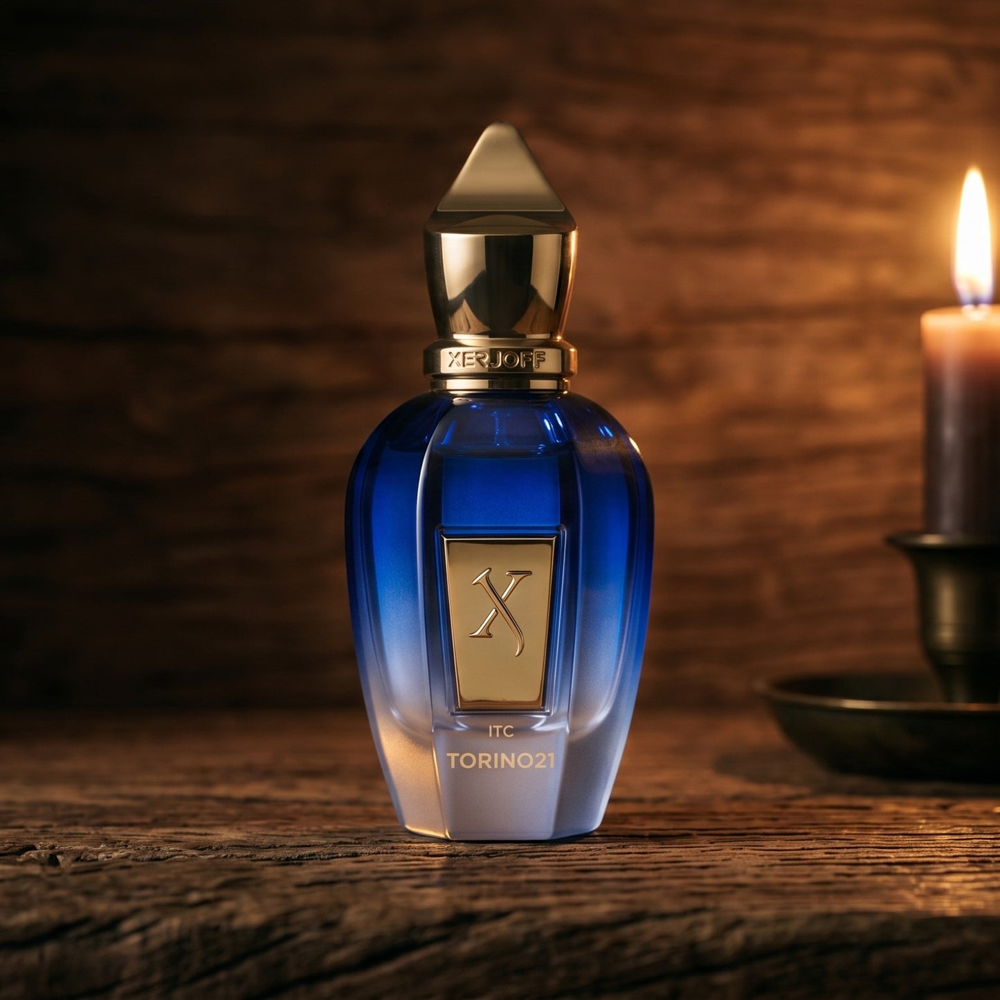 Xerjoff Torino 21 on aged teak with a candle burning gently to frame-right