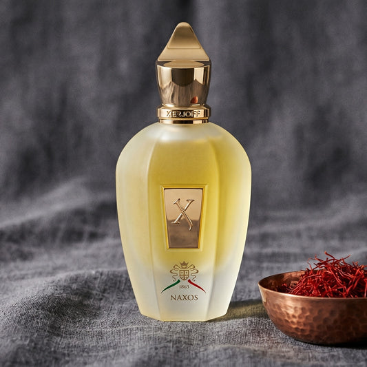 Xerjoff XJ 1861 Naxos on obsidian surface with a brass bowl of red saffron stamens