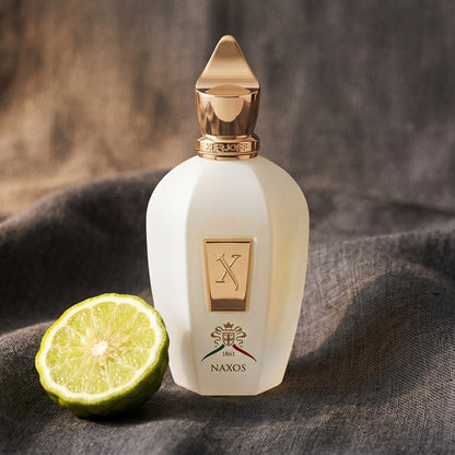 Xerjoff XJ 1861 Naxos on charcoal linen with a halved bergamot