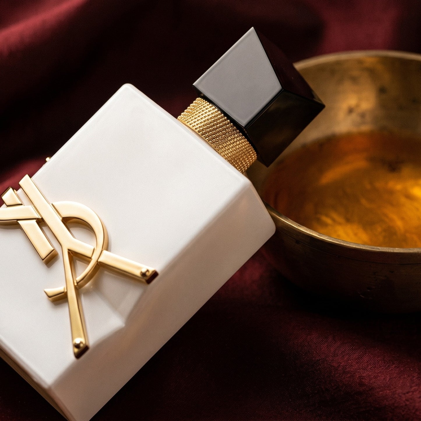 Yves Saint Laurent Libre L Eau Nue Perfume de Peau on deep caramel velvet with a small copper jar of resin balm