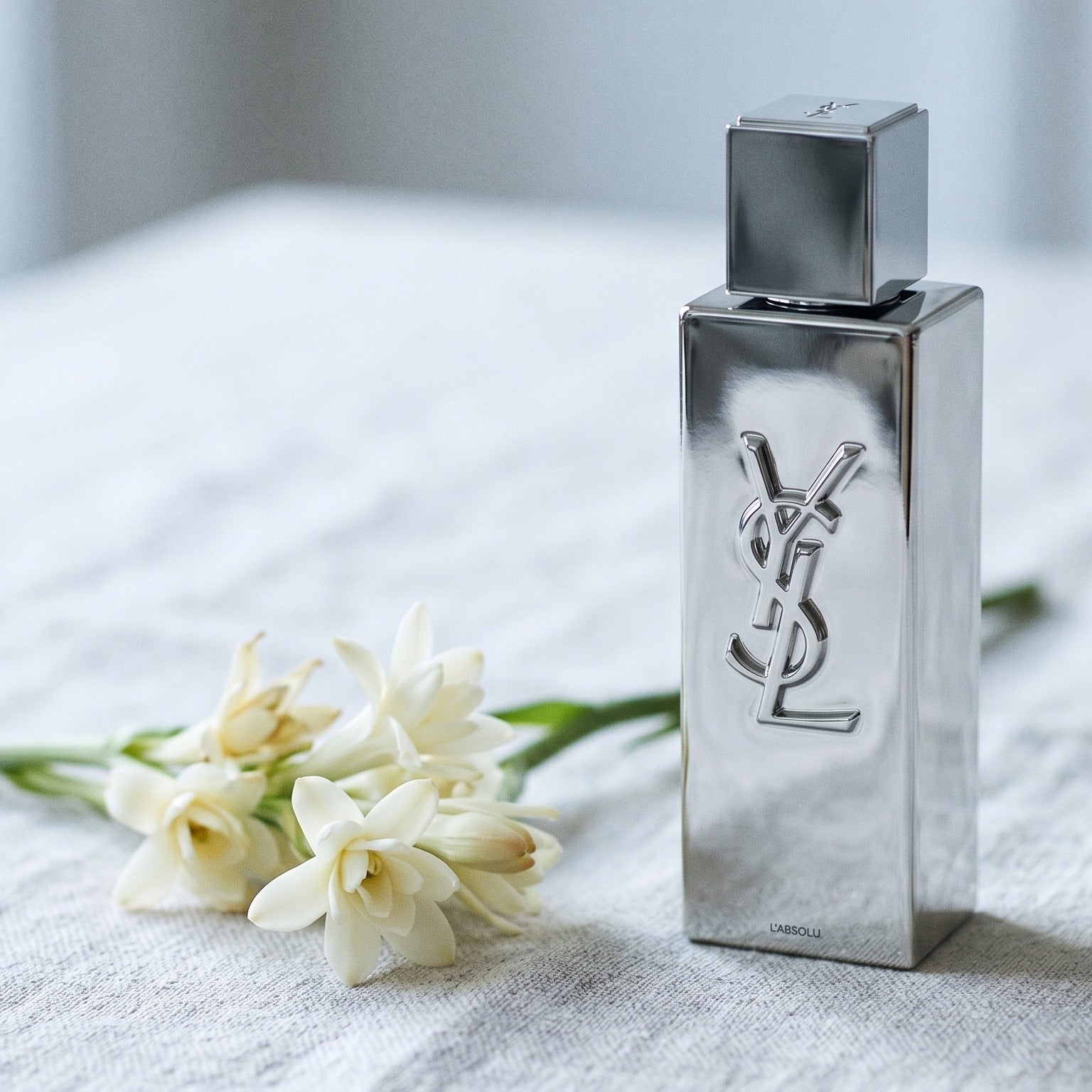 Yves Saint Laurent Myslf L Absolu Parfum on cream-toned linen with a jasmine vine coiled loosely
